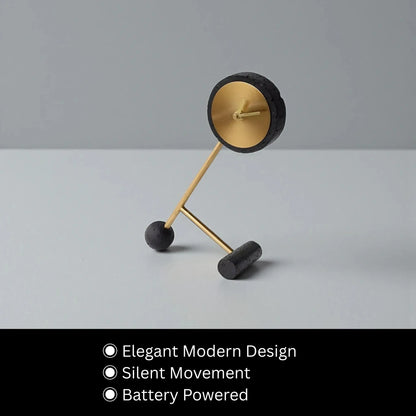 Metal Tabletop Clock - Winsley with an elegant modern design features a matte black and gold open-face showcasing decorative gears, perched on angled gold rods with silent movement, battery-powered, perfect for desks or mantels.