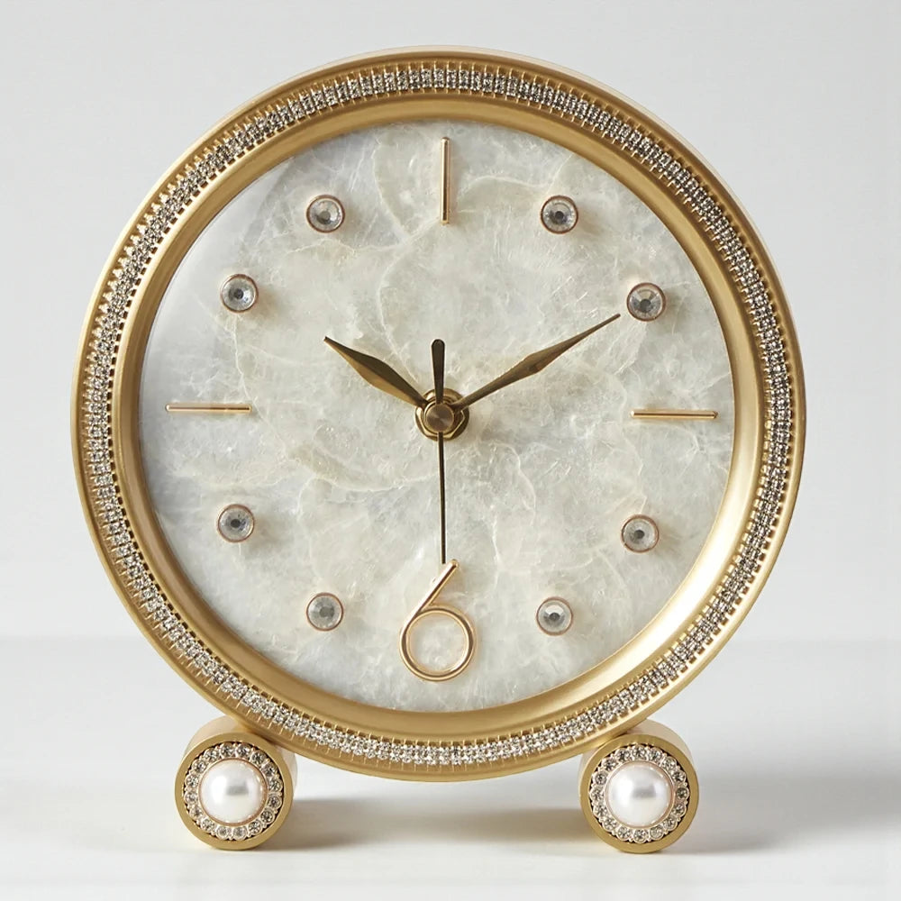 Silent Table Clock - Feynor: This elegant clock features a gold-toned frame, marbled face, minimalist gold indices, crystal accents, and faux pearl-topped legs, ideal for enhancing home decor with style.