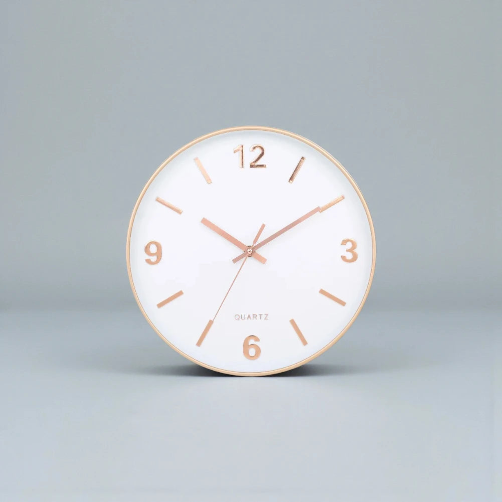 Modern Silent Wall Clock - Densford features a sleek, round design with a white face, gold-tone rim, and elegant numerals, offering a contemporary, silent accent to any room.