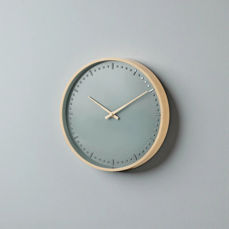 Small modern wall clock - Merrin: A minimalist wall clock with a light wood frame, muted gray-blue dial, and simple hour markers, blending Nordic design with silent German craftsmanship for a stylish, quiet focal point.
