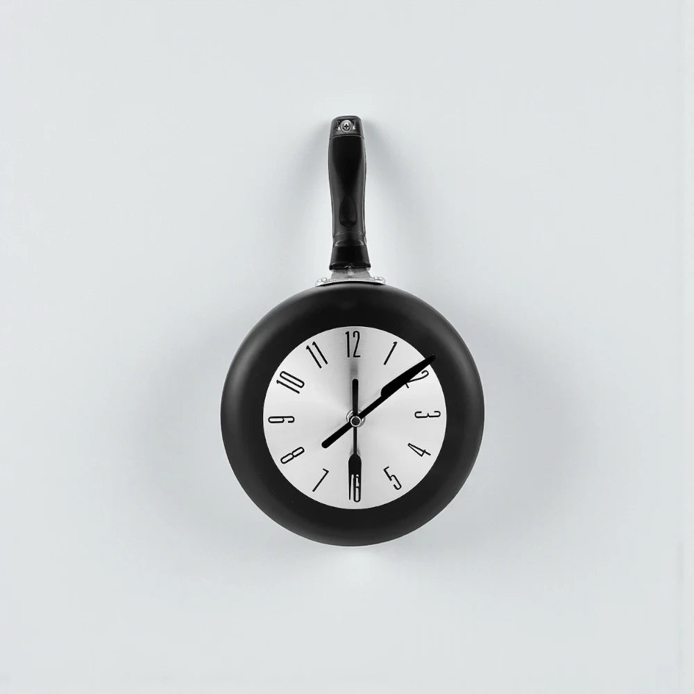 Frying Pan Wall Clock - Ashford: A quirky wall clock with a frying pan design, featuring a fried egg clock face and utensil-shaped hands, perfect for adding culinary charm to any kitchen.