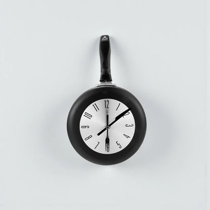 Frying Pan Wall Clock - Ashford: A quirky wall clock with a frying pan design, featuring a fried egg clock face and utensil-shaped hands, perfect for adding culinary charm to any kitchen.