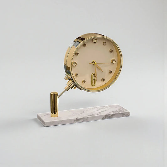 Luxury Table Clock - Corlen: A decorative desk clock with a brass-finished face, crystal hour markers, and a large “6,” mounted on a brass stem over a white marble base.