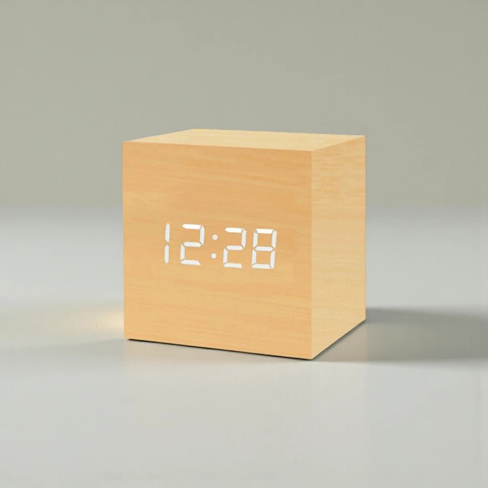 Cube Alarm Clock - Corven: A sleek, cube-shaped digital clock with a wooden texture and white LED display showing 12:28, ideal for modern bedside tables.