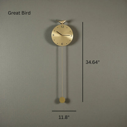 Modern pendulum wall clock - Majesty: A minimalist wall clock with a bird-topped round face, marked hours, and a long pendulum in warm metallic finish, measuring 11.8″ wide by 34.64″ tall.