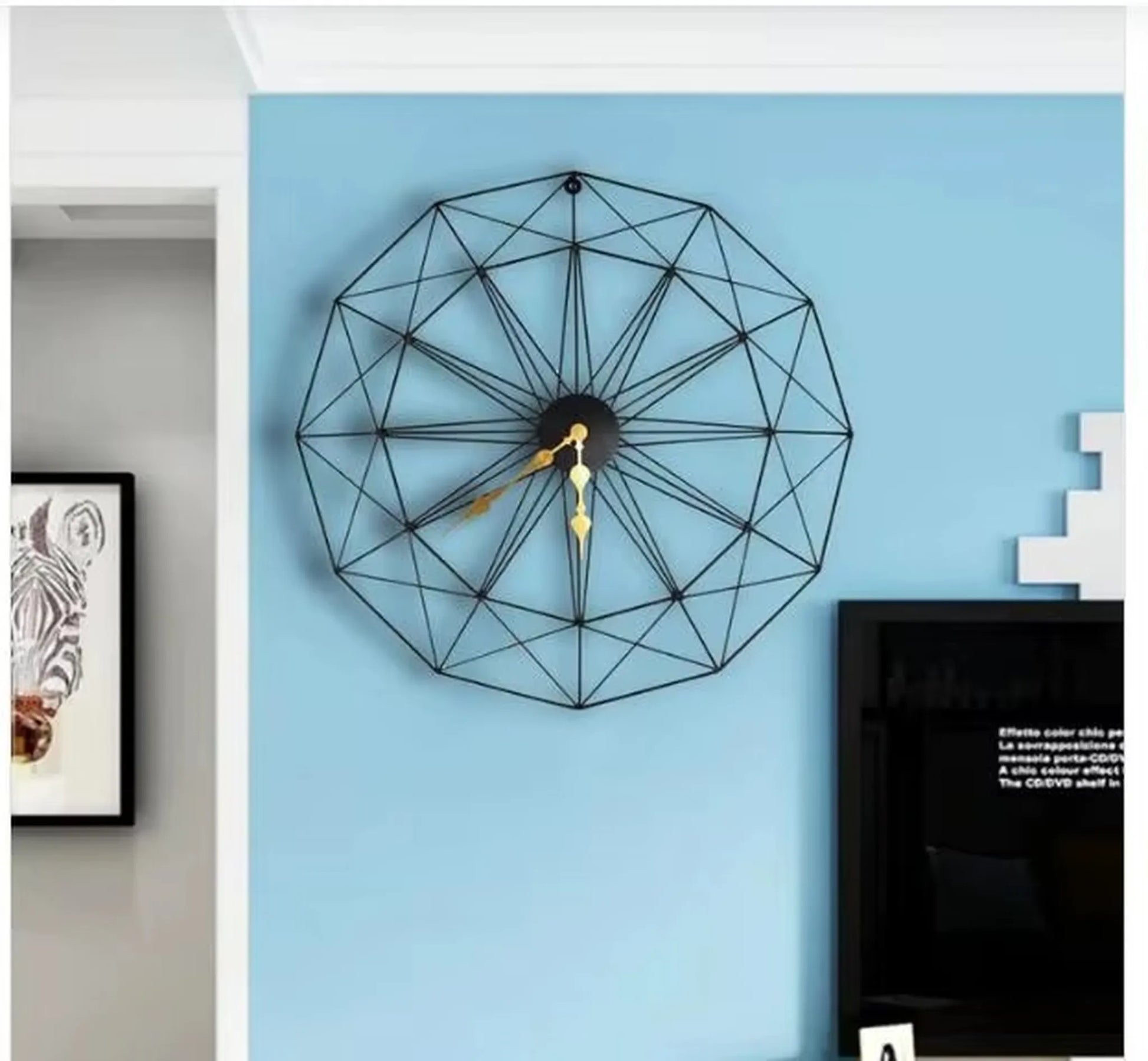 Modern Style Wall Clock - Blenford: A geometric wire-frame clock with gold hands, mounted on a sky-blue wall, embodying minimalist elegance. Visible alongside a zebra illustration and part of a media console.