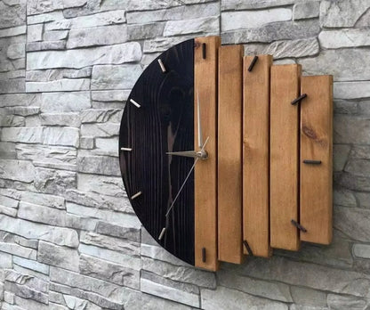 Modern wood wall clock - Clevor: This handcrafted clock features a black-stained semicircle and vertical wooden slats, accented with metal tick marks and silver hands, mounted on a textured stone-tile wall.