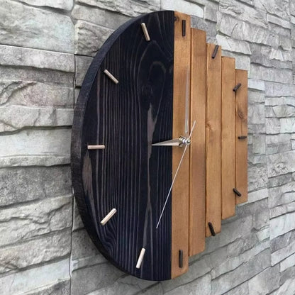 Modern wood wall clock - Clevor, featuring a circular design with a dual-tone face of black-stained and natural wood slats, complemented by cylindrical wooden hour markers and sleek metal hands.