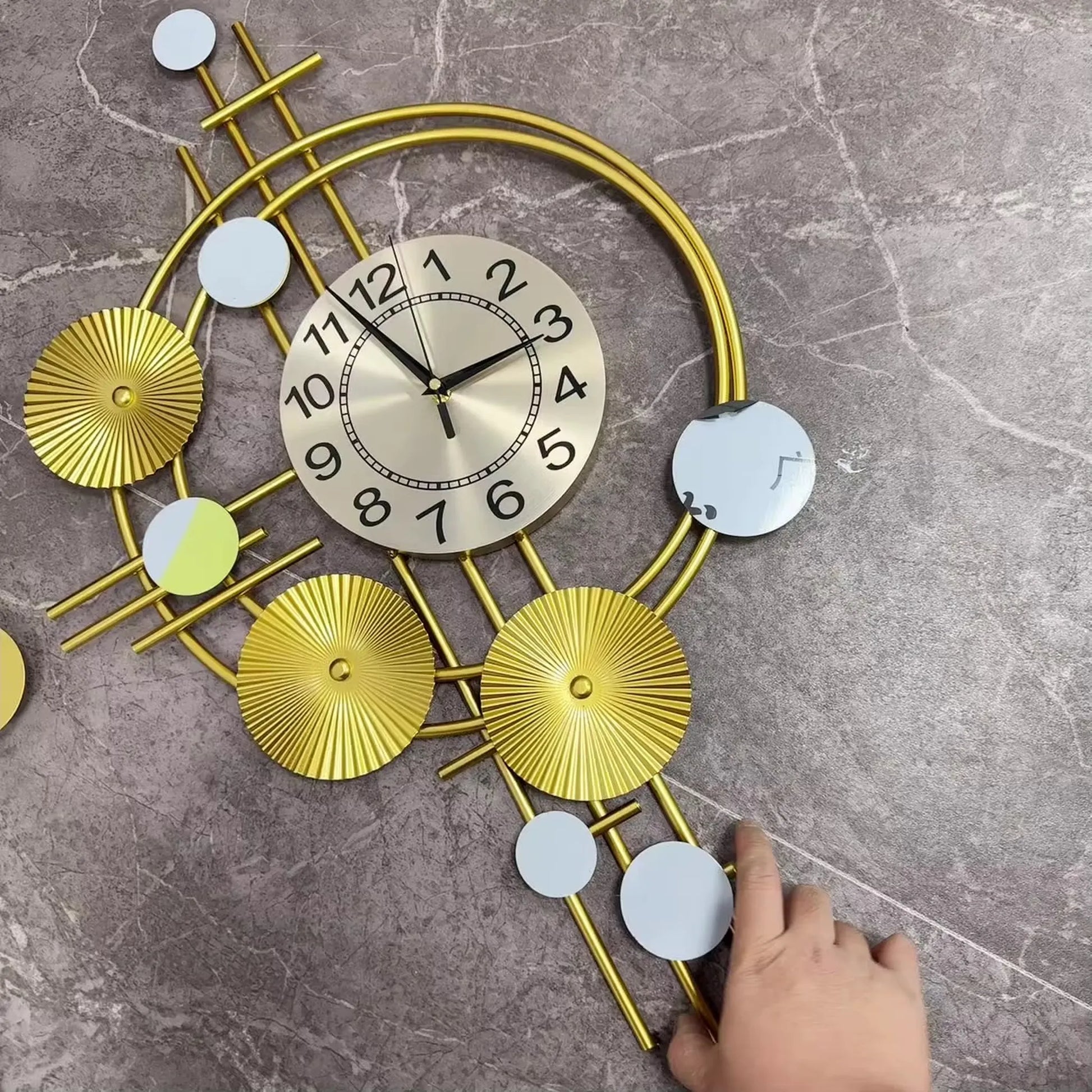 Oversized wall clock modern - Hashford features a gold-tone face with black hands, encased in a sculptural framework of intersecting gold rods and decorative discs, offering contemporary elegance and silent timekeeping.