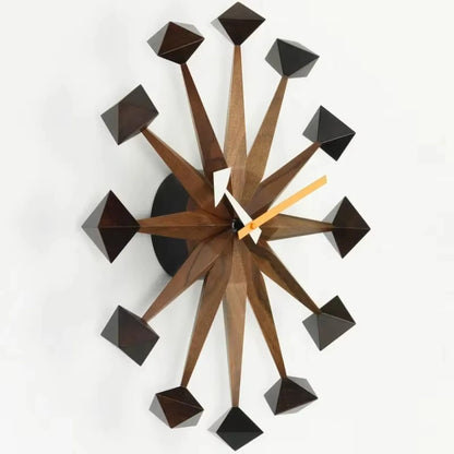 Decorative wall clocks modern - Drayen: A mid-century design with 12 wooden spokes and polyhedral tips, featuring white and orange clock hands, ideal for contemporary spaces.