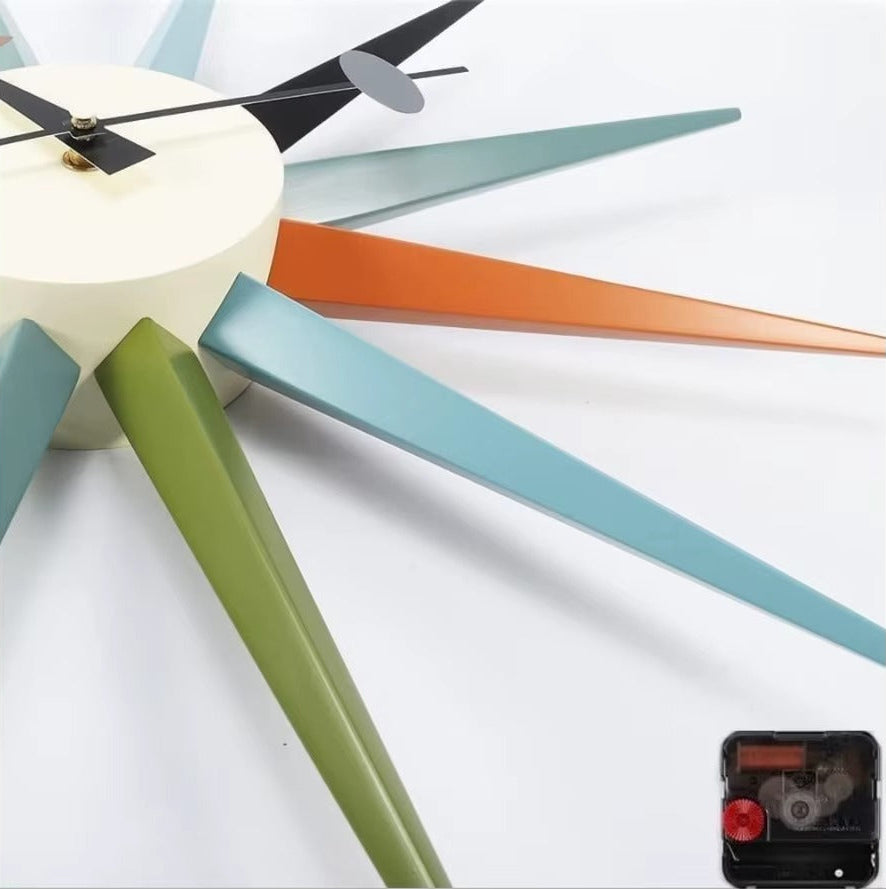 Rovell: A mid-century-style clock featuring a central dial with long, colorful metal rays and simple black hands