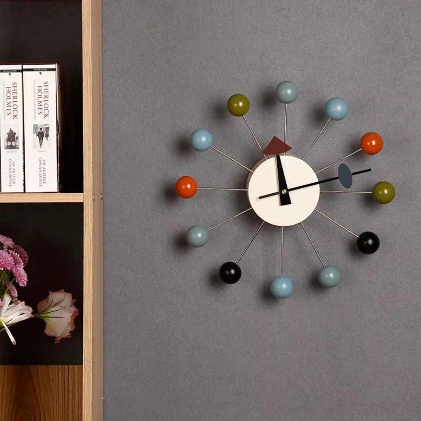 Turquoise and coral spheres catching natural light on sunburst wall clock