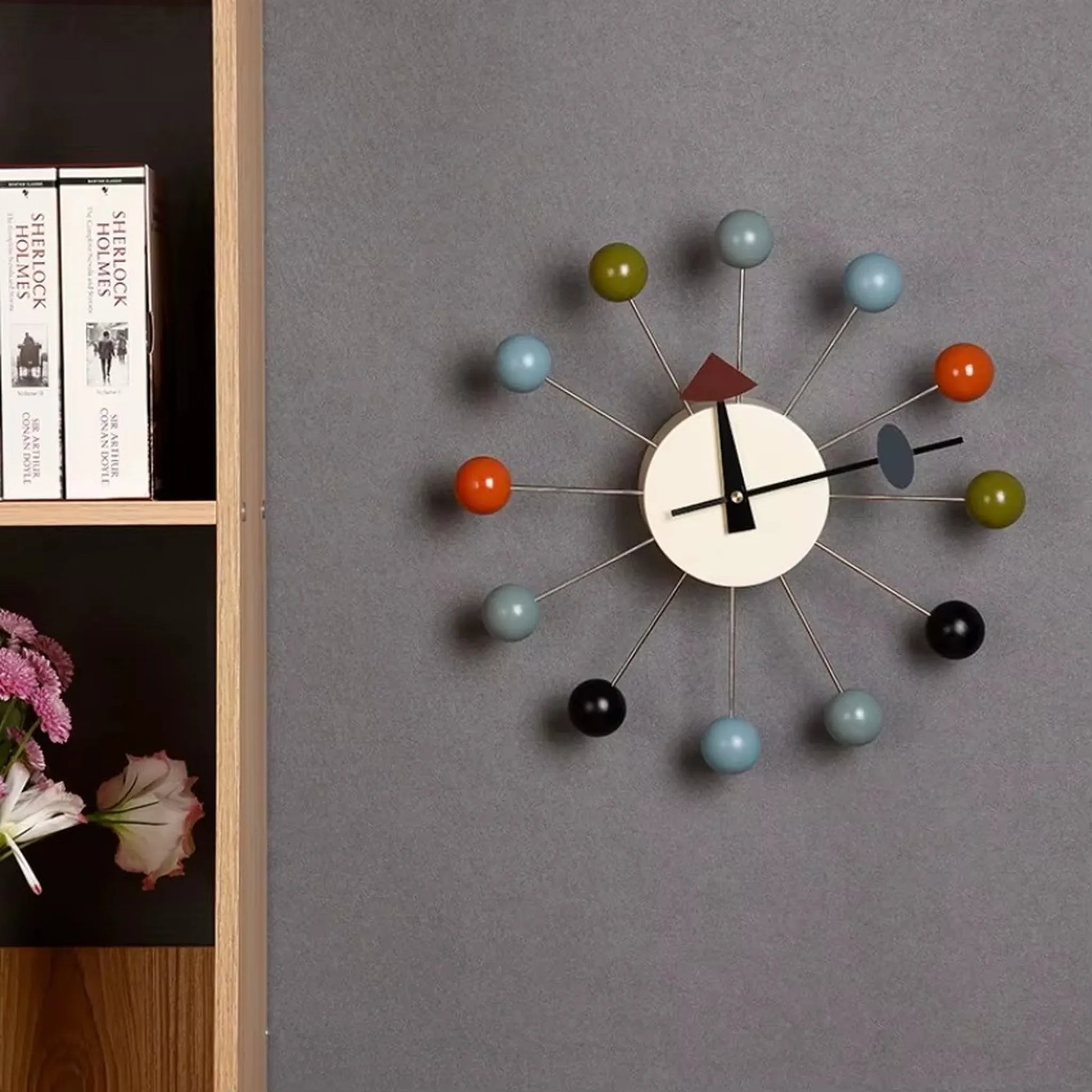Turquoise and coral spheres catching natural light on sunburst wall clock