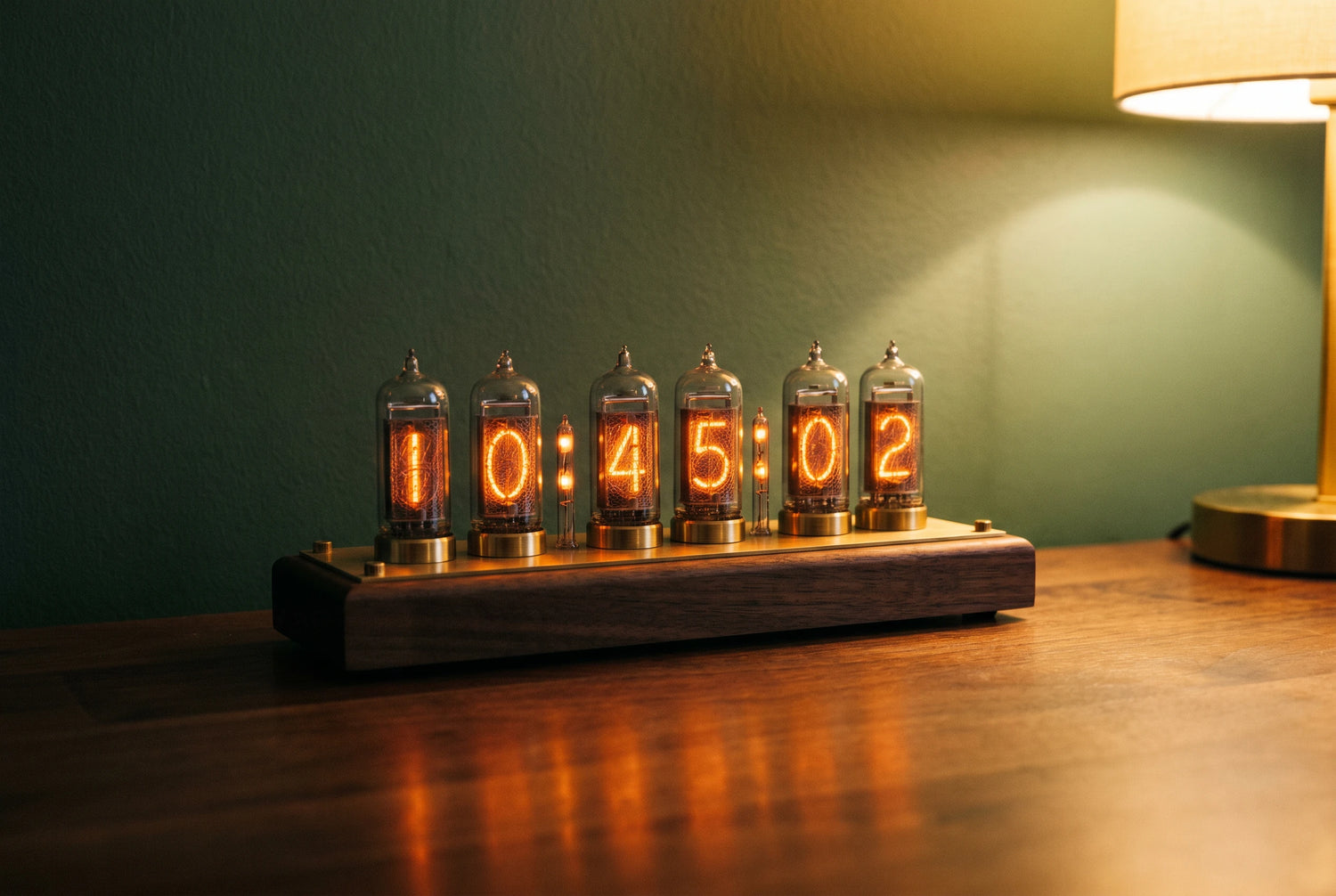 Vintage nixie tube clock with glowing orange digits on a dark walnut desk